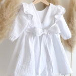Bijela muslin haljina jednostavnog kroja za bebe.