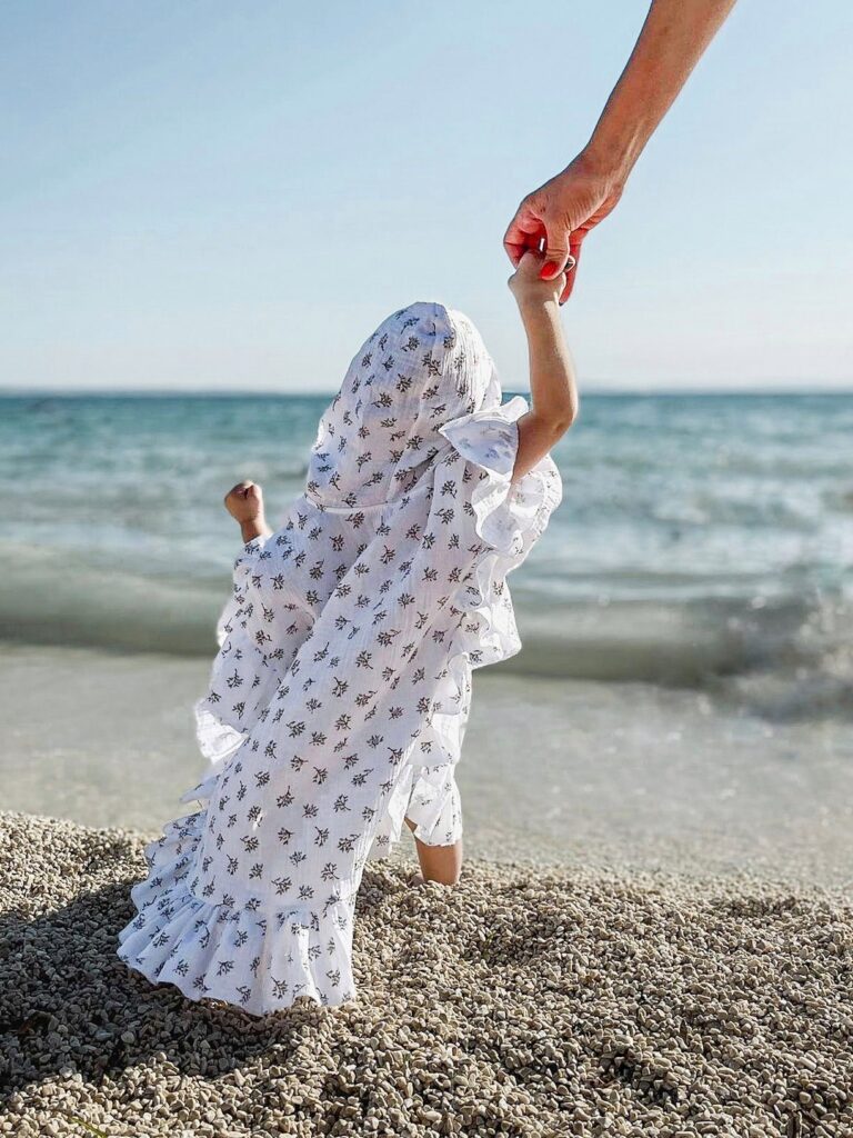 Dijete u dječjem ponču na pješčanoj plaži.